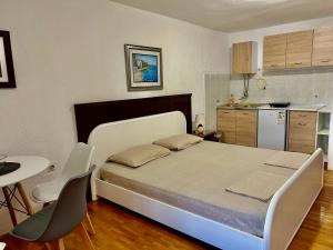 1 dormitorio con 1 cama, mesa y sillas en Apartments Jankovic, en Podgorica