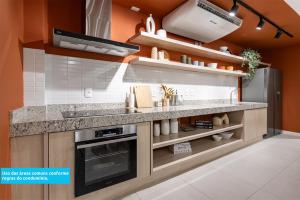 a kitchen with a counter and a refrigerator at Lobie Casa Mauá in Rio de Janeiro