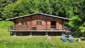 uma cabana de madeira com duas cadeiras azuis em frente em Chalet d'alpage avec vue incroyable em Saint-Gervais-les-Bains