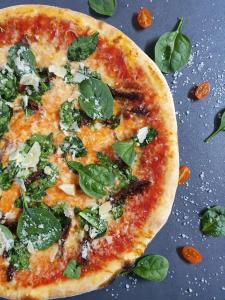 une pizza avec des épinards et du fromage sur une table dans l'établissement Hotel & Restaurace Pizzerie Jasany, à Znojmo