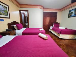 um quarto de hotel com duas camas com lençóis cor-de-rosa em Hotel Diamante Azul em La Paz