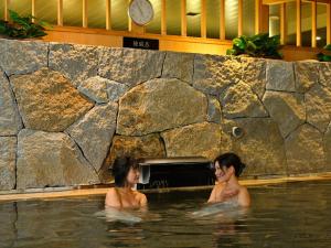 twee vrouwen in het water in een zwembad bij Himeji Castle Grandvrio Hotel in Himeji