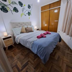 a bedroom with a bed with two pink slippers on it at Córdoba Te Espera in Cordoba