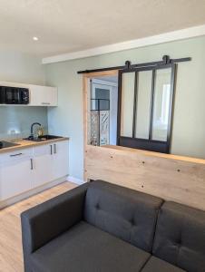 sala de estar con sofá y cocina en Appartement au cœur des alpes, en Albertville