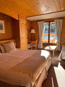 um quarto com uma cama grande num quarto com uma mesa em Hôtel Le Jeu de Paume em Chamonix-Mont-Blanc