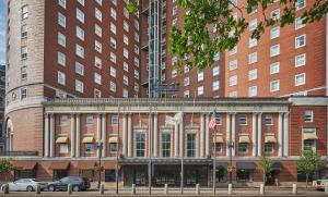 un grand bâtiment en briques avec deux drapeaux américains devant dans l'établissement Graduate by Hilton Providence, à Providence