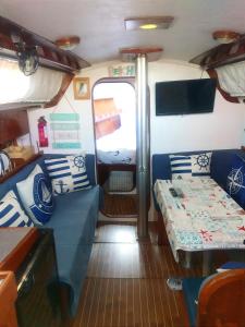 una camera con divano e un letto in autobus di Houseboat - Faro in Ria Formosa a Faro