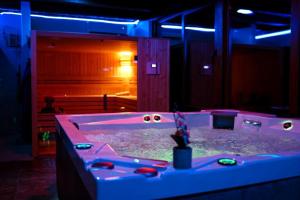 a lit up room with a tub filled with water at Hanu lui Gica Spa in Satu Mare