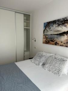 um quarto com uma cama branca e uma pintura na parede em Victoria Apartments em Budva