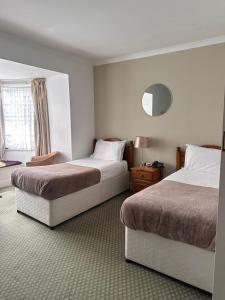 um quarto de hotel com duas camas e uma janela em Tyacks Hotel em Camborne