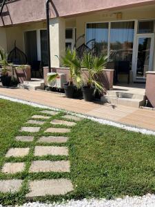 una casa con una pasarela con plantas delante de ella en Apartment & Studio Traky, Saint Vlas, улица Черно Море 12, en Sveti Vlas