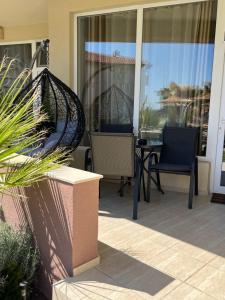 un patio con 2 sillas y una mesa en un porche en Apartment & Studio Traky, Saint Vlas, улица Черно Море 12, en Sveti Vlas