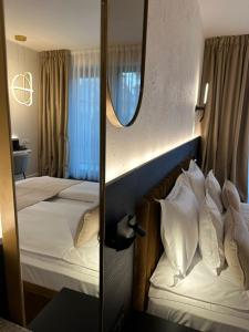 two beds in a hotel room with a mirror at Element in Alba Iulia