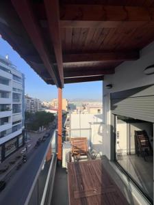 een balkon met een houten bank op een gebouw bij Νεόκτιστο διαμέρισμα Πειραιάς in Piraeus