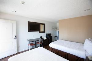 ein Hotelzimmer mit 2 Betten und einem Schreibtisch in der Unterkunft Budget Inn Expressway Hub in Rohnert Park