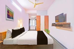 - une chambre avec un grand lit et un ventilateur de plafond dans l'établissement Collection O De Alphabet Hotel UMCC, à Hyderabad