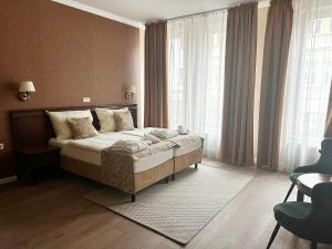 um quarto com uma cama num quarto com janelas em Wellness Hotel Pivovar Monopol em Teplice