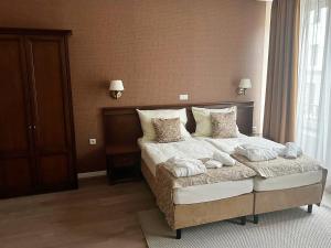 um quarto com uma cama com lençóis brancos e almofadas em Wellness Hotel Pivovar Monopol em Teplice