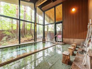 einen Pool in einem Haus mit einem großen Fenster in der Unterkunft 蔵王温泉 岩清水料理の宿 季の里 in Zao Onsen