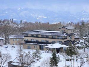 ein großes Gebäude mit Schnee auf dem Boden in der Unterkunft 蔵王温泉 岩清水料理の宿 季の里 in Zao Onsen