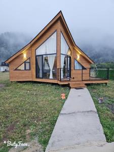 una casa con una gran ventana en un campo en Cottage Liantto, en Borjomi