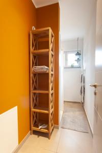 Cette chambre est dotée de murs orange et d'étagères en bois. dans l'établissement Stilvolles Ambiente im grünen Hamburg!, à Hambourg