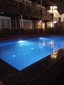 una grande piscina notturna con luci blu di Satva Cottages ad Anjuna