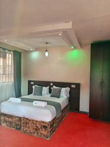 een slaapkamer met een groot bed en een rode loper bij The Grand Alton Resort Kisumu in Kisumu