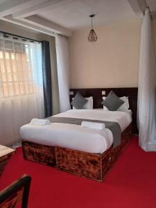 een slaapkamer met een groot bed en een rode loper bij The Grand Alton Resort Kisumu in Kisumu