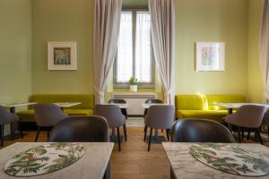 een restaurant met tafels en stoelen en een raam bij Hotel Ariele in Florence