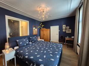 ein blaues Schlafzimmer mit einem Bett und einem Kronleuchter in der Unterkunft B&B van Zon aan Zee in Vlissingen