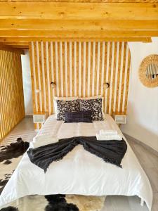 a bedroom with a large bed with a wooden wall at Casinhas dos Valados in Atouguia da Baleia