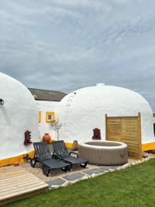 a couple of chairs sitting in front of two domes at Casinhas dos Valados in Atouguia da Baleia