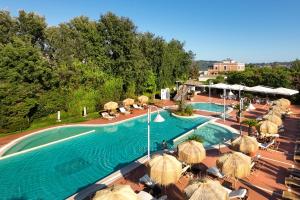 een buitenzwembad met parasols en stoelen en een zwembad bij Montespina Park Hotel in Napels