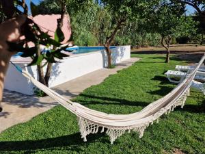 a hammock in a park next to a pool at Quinta da Ponte das Hortas 1 in Elvas