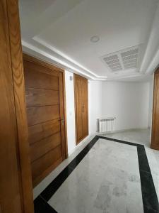 Luxury Apartment Menzah 9C في تونس: غرفه فاضيه فيها باب ودوره