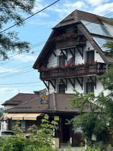 um edifício com uma varanda e flores sobre ele em Trattoria Al Gallo em Bran