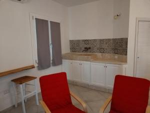 a kitchen with two red chairs and a sink at MarMè in San Teodoro