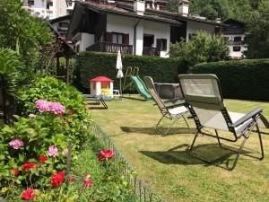 twee ligstoelen in een tuin met bloemen bij Maison Laurent in Courmayeur