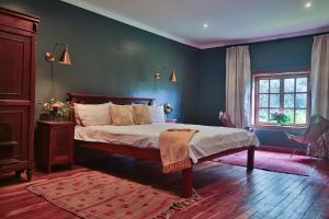 een slaapkamer met een bed en een blauwe muur bij Mukima Manor in Nanyuki