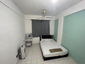 Blissful Breeze 4 ROOMS & NETFLIX by EZYROOM MELAKA في آير كيروه: غرفة صغيرة بها سرير وطاولة