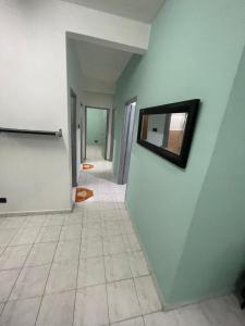 Blissful Breeze 4 ROOMS & NETFLIX by EZYROOM MELAKA في آير كيروه: ممر فارغ مع مرآة على الحائط