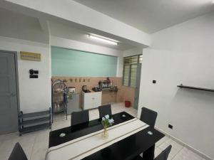 Blissful Breeze 4 ROOMS & NETFLIX by EZYROOM MELAKA في آير كيروه: غرفة مع طاولة وكراسي ومطبخ