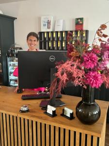 une femme assise sur un bureau avec un ordinateur dans l'établissement DK Hotel Deutscher Kaiser, à Heidelberg