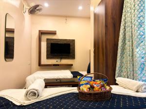 una habitación de hotel con 2 camas y una cesta de patatas fritas en HOTEL VIA GANGA INN ! గంగా ఇన్ ద్వారా హోటల్ VARANASI! FULLY AIR-CONDITIONED HOTEL AT PRIME LOCATION WITH ROOFTOP GANGES VIEW! 2 Min walking distance from ASSI GHAT ,NEAR KASHI VISHWANATH TEMPLE, en Varanasi