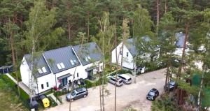 una vista aérea de una casa con coches aparcados en un aparcamiento en La Brisa Apartments, en Dziwnówek