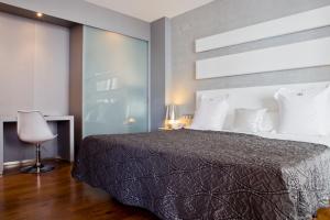 - une chambre avec un grand lit et une chaise dans l'établissement Num Hotel, à Salou