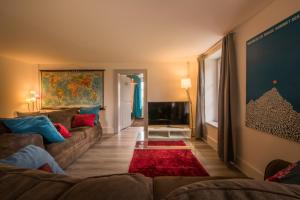 a living room with a couch and a tv at Dependance Penthouse in Interlaken