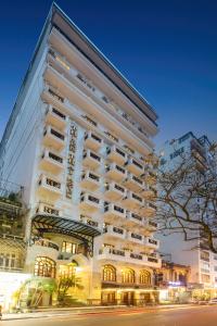 ein hohes weißes Gebäude mit Fenstern und einer Straße in der Unterkunft Thien Thai Hotel & Spa in Hanoi