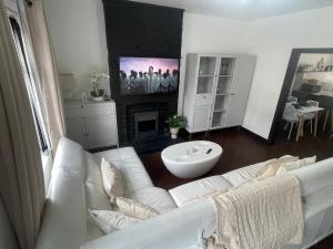 a living room with a white couch and a fireplace at Slick Space for a Standish Stay in Standish